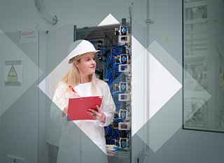 Woman with hard hat and clipboard writes something