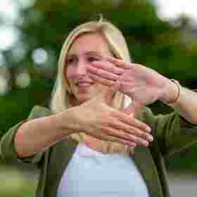 Frau zeigt mit den Händen eine Raute