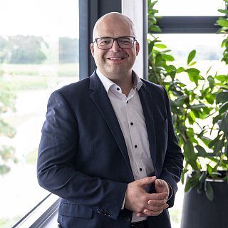 Mann in Anzug lächelt in Kamera